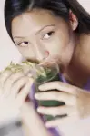 beautiful black woman drinking a green concoction